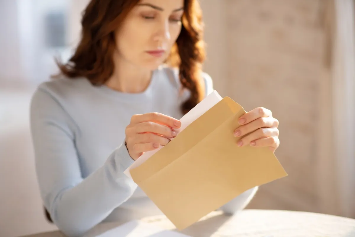 Femme ouvrant un courrier de l’administration au sujet de son permis